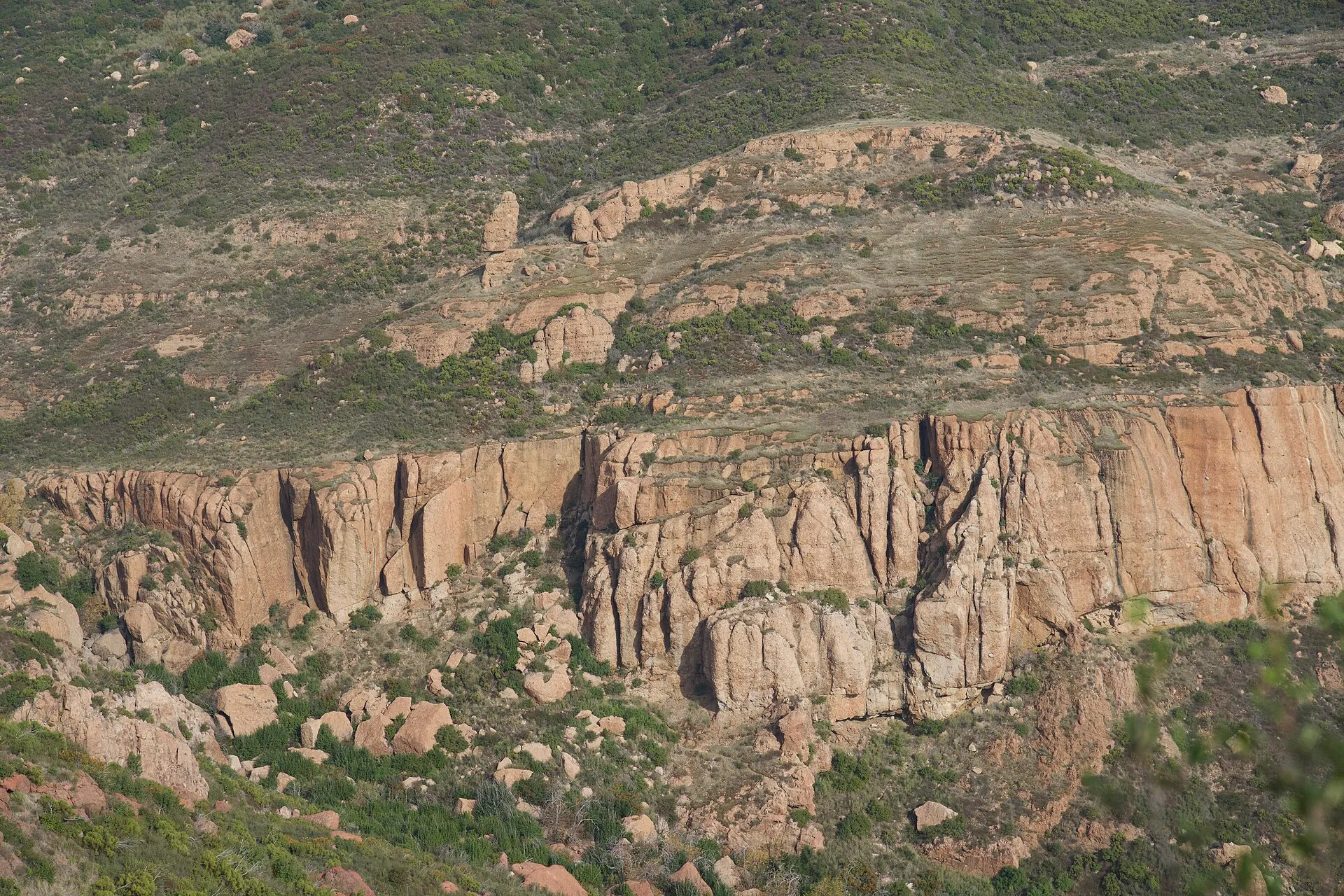 The long volcanic wall of Echo Cliffs above green chaparral